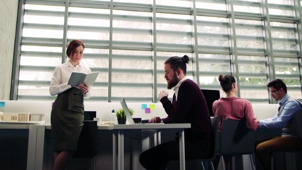 A group of young businesspeople working together in office, talking.