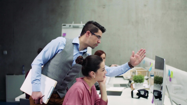 A group of young businesspeople working together in office, talking.