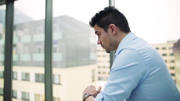 A portrait of young businessman indoors in an office. Slow motion.