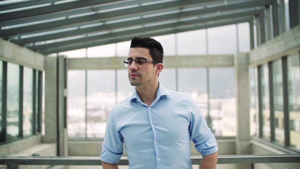 A portrait of young businessman indoors in an office. Slow motion.