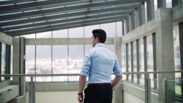 A portrait of young businessman indoors in an office. Slow motion.