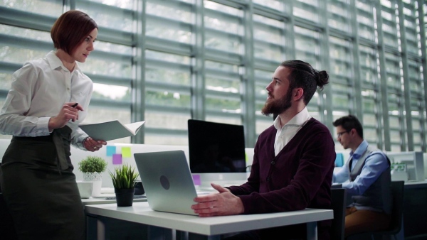 A group of young businesspeople working together in office, talking. Slow motion.