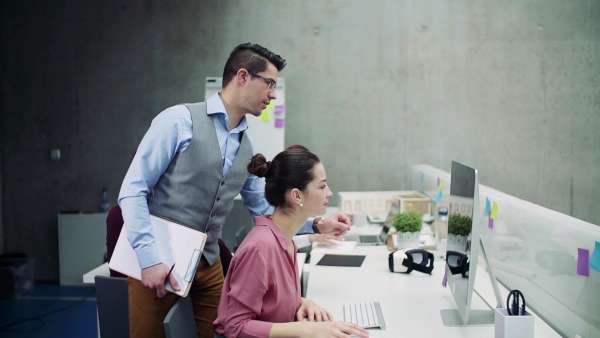 A group of young businesspeople working together in office, talking. Slow motion.