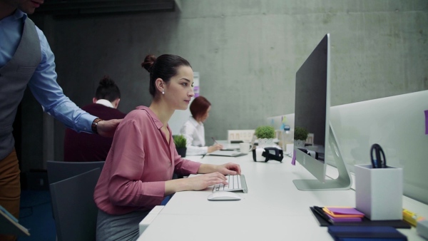 A group of young businesspeople working together in office, talking. Slow motion.