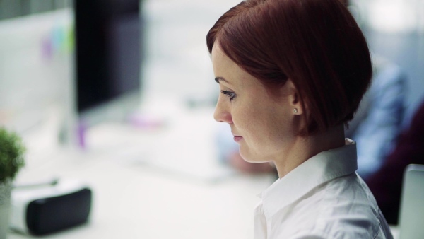 Portrait of female young businesswoman with colleagues in office, working. Slow motion.