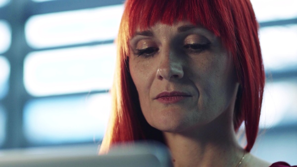 A close-up portrait of mature businesswoman sitting at desk in office, working.