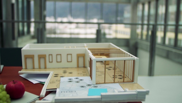 A model of a house on the desk in an empty office.