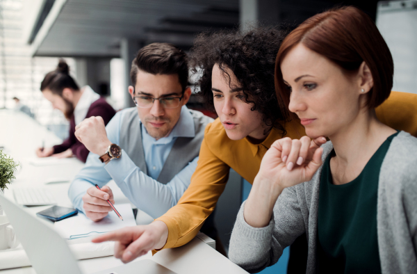 A group of young businesspeople working together in office, talking.