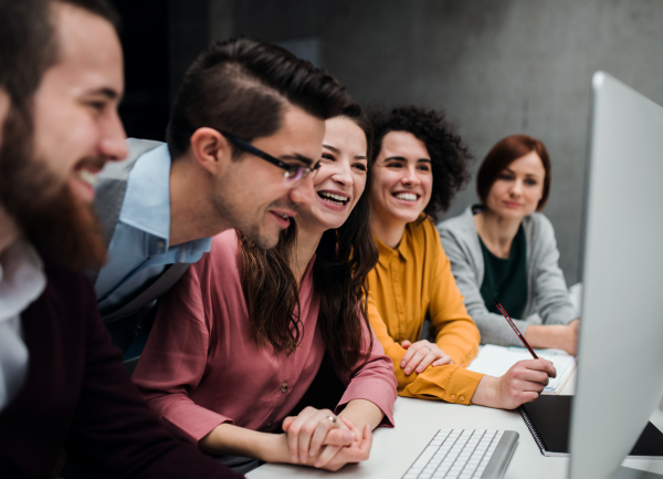 A group of young businesspeople working together in office, talking.