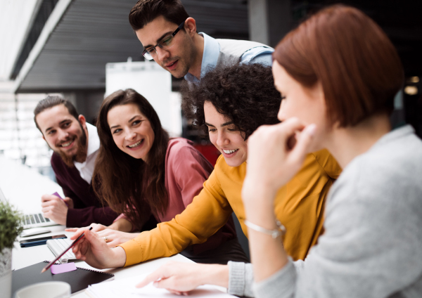 A group of young businesspeople working together in office, talking.