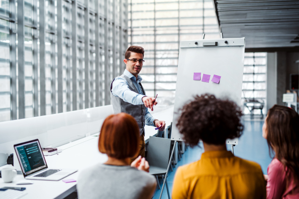 A group of young businesspeople in office, listening to a presentation.