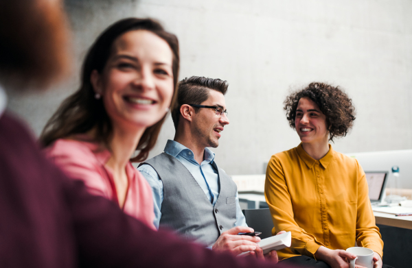 A group of young businesspeople working together in office, talking.