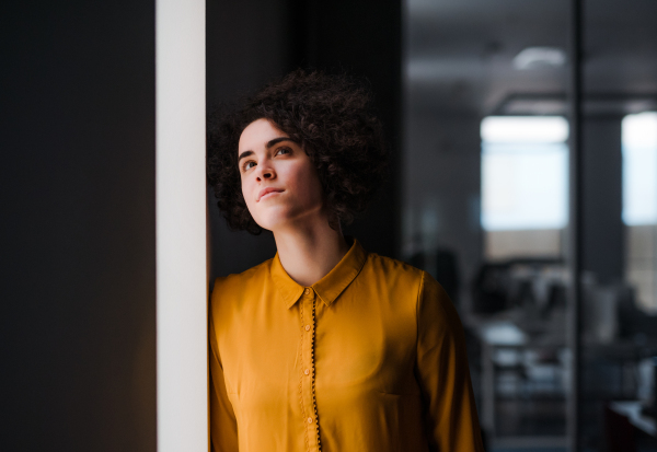 A portrait of a young businesswoman indoors in an office. Copy space.