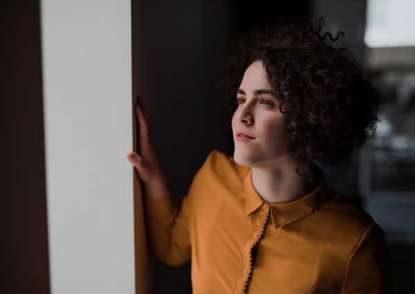 Portrait of a young cheerful businesswoman indoors in an office, resting. Copy space.