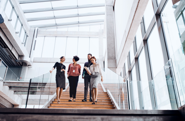 A group of young businesspeople walking down the stairs, talking.