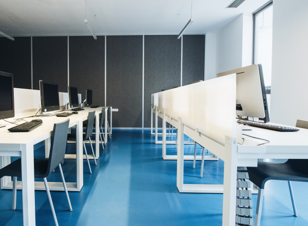 An interior of a modern spacious computer room for students in a library or office.