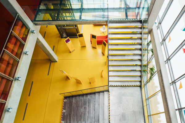 High-angle view of yellow interior of a modern spacious library with computers for public.