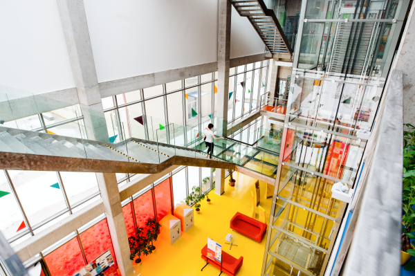 High-angle view of yellow interior of a modern spacious library with computers for public.