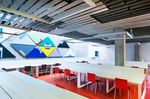 An interior of a modern spacious study room for students in a library or office.