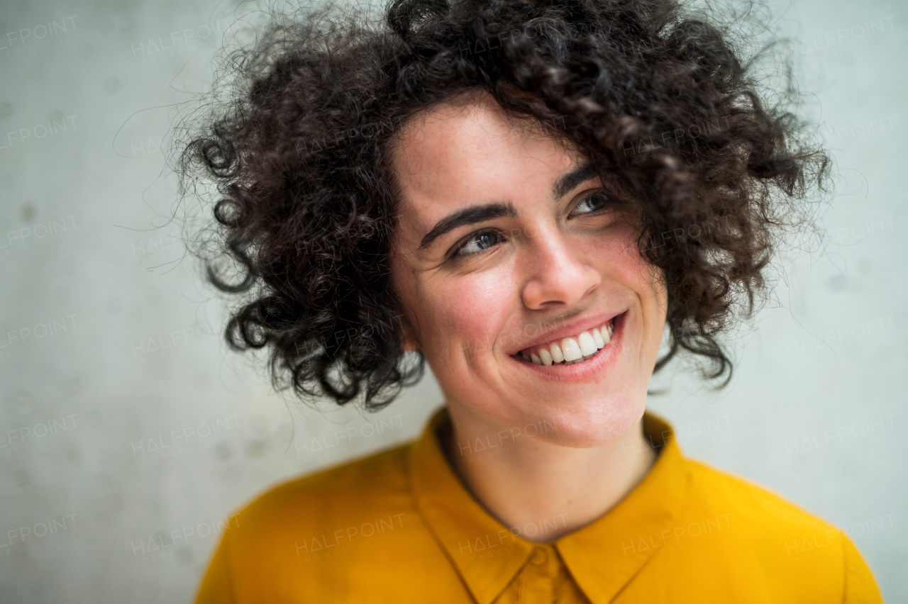 A portrait of a young student or businesswoman standing in room in a library or office.