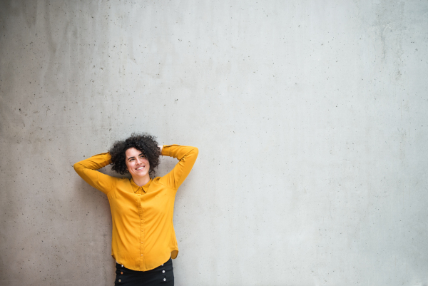 A portrait of a young student or businesswoman standing in room in a library or office. Copy space.