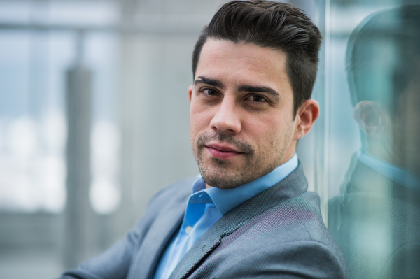 A portrait of young businessman indoors in an office. A close-up.