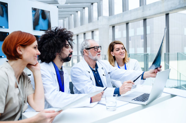 A group of doctors looking at X-ray on medical conference, discussing issues.