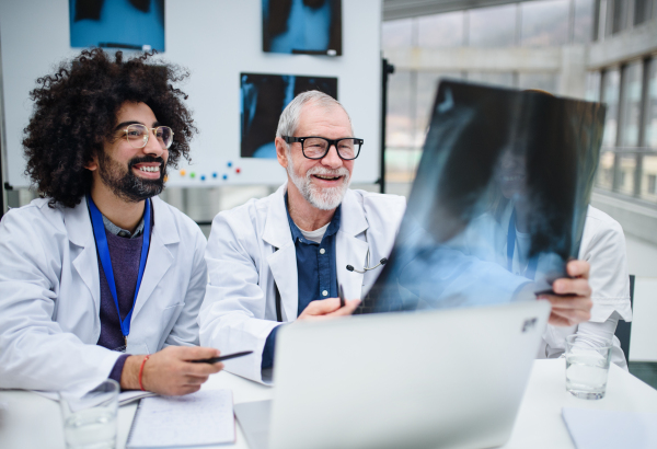 A group of doctors looking at X-ray on medical conference, discussing issues.