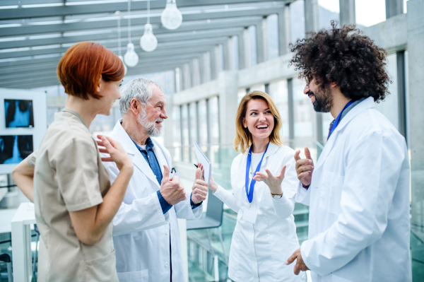 Group of doctors standing on conference, medical team laughing when discussing issues.