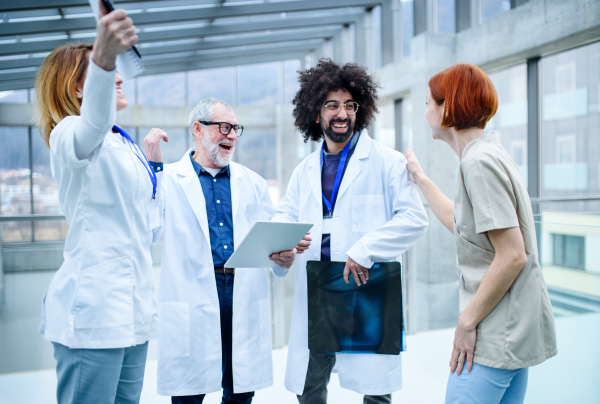 Group of doctors standing on conference, medical team laughing when discussing issues.