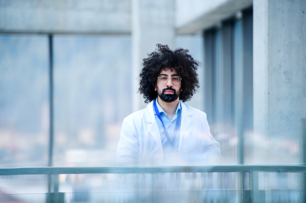 Front view portrait of male doctor standing in hospital. Copy space.