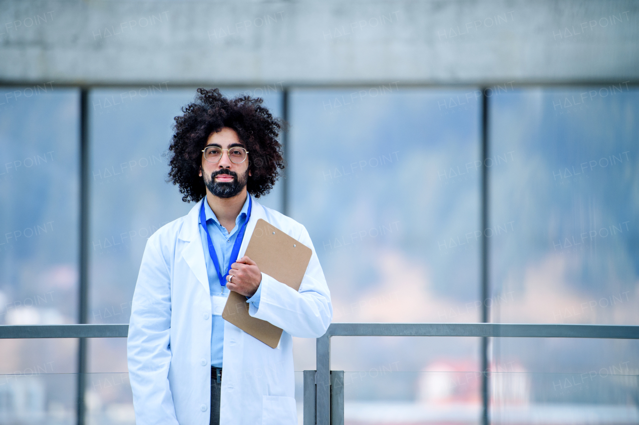 Portrait of male doctor standing in hospital, looking at camera. Copy space.