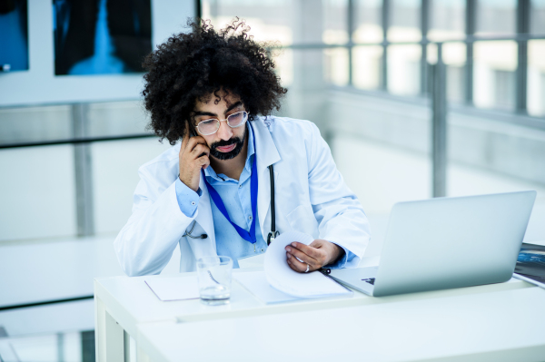 Portrait of thoughtful male doctor with X-ray in hospital, corona virus concept.