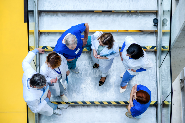 Top view of group of doctors standing on stairs on conference, talking.