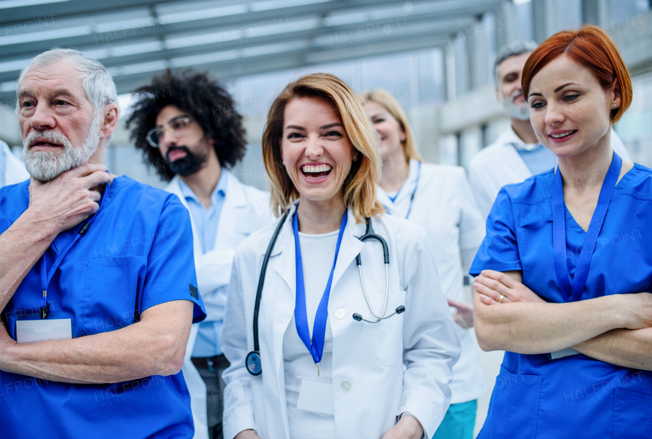 Group of doctors standing on conference, medical team laughing when discussing issues.