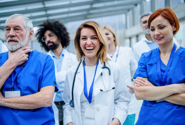 Group of doctors standing on conference, medical team laughing when discussing issues.