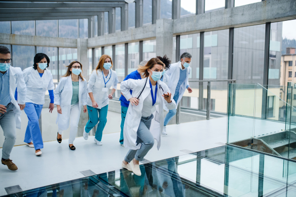 Group of doctors in hurry running in corridor of hospital, emergency concept.