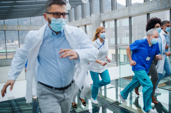 Group of doctors in hurry running in corridor of hospital, emergency concept.