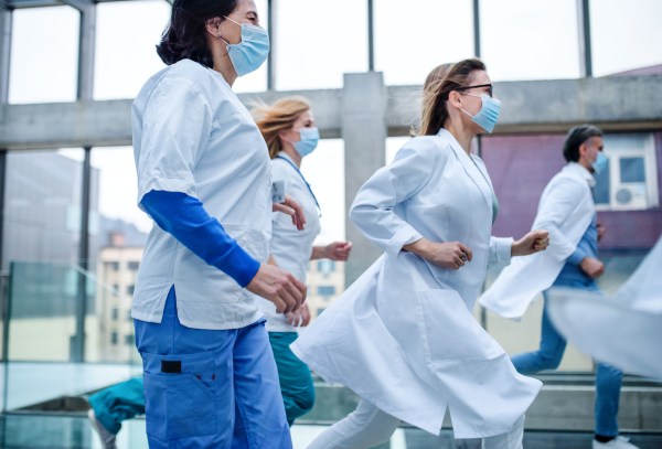 Group of doctors in hurry running in corridor of hospital, emergency concept.