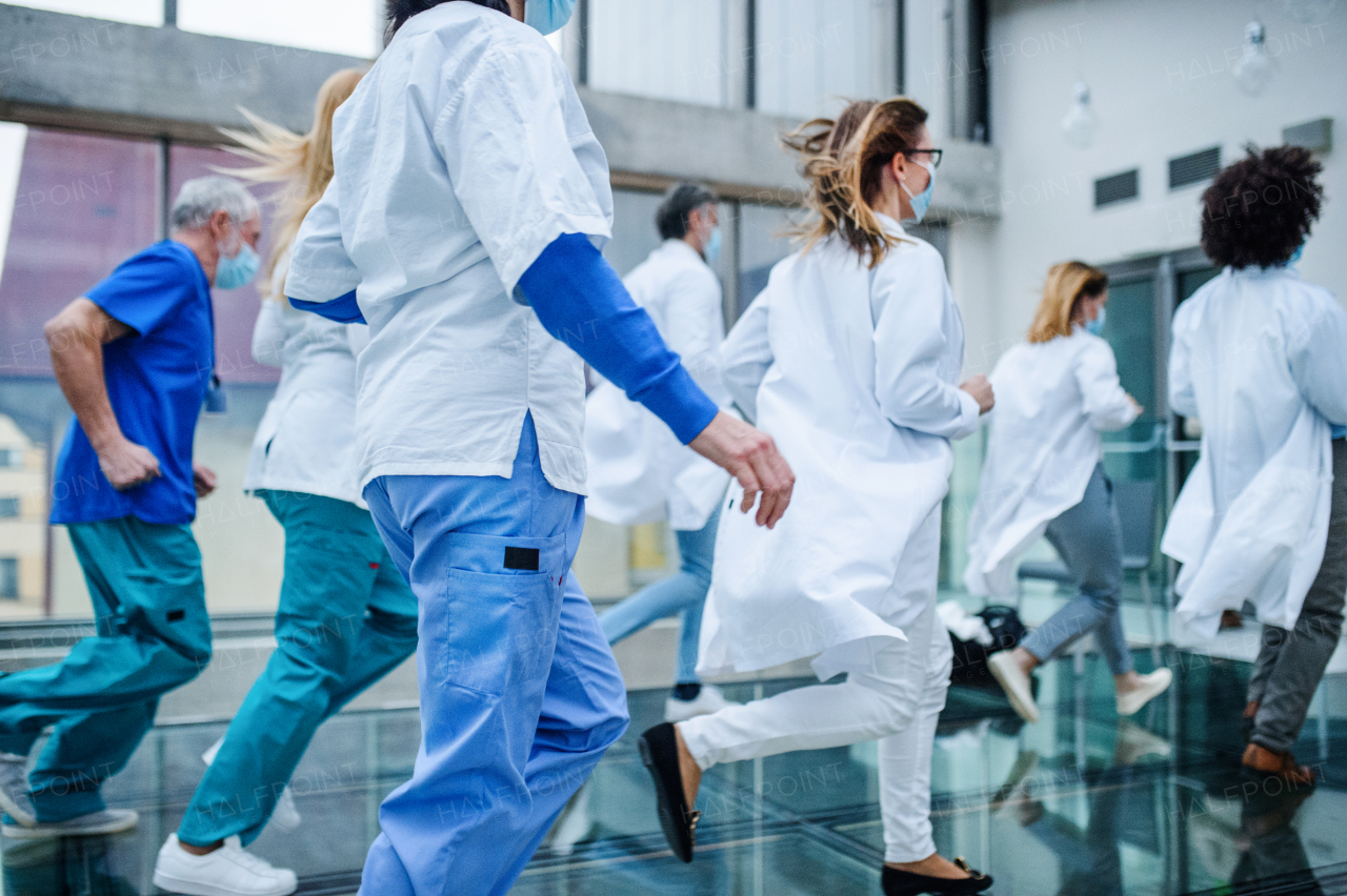 Group of doctors in hurry running in corridor of hospital, emergency concept.