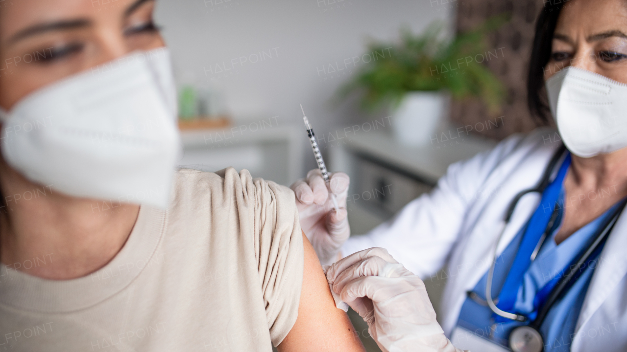 Mid woman with respirator getting vaccinated in hospital, coronavirus and vaccination concept.