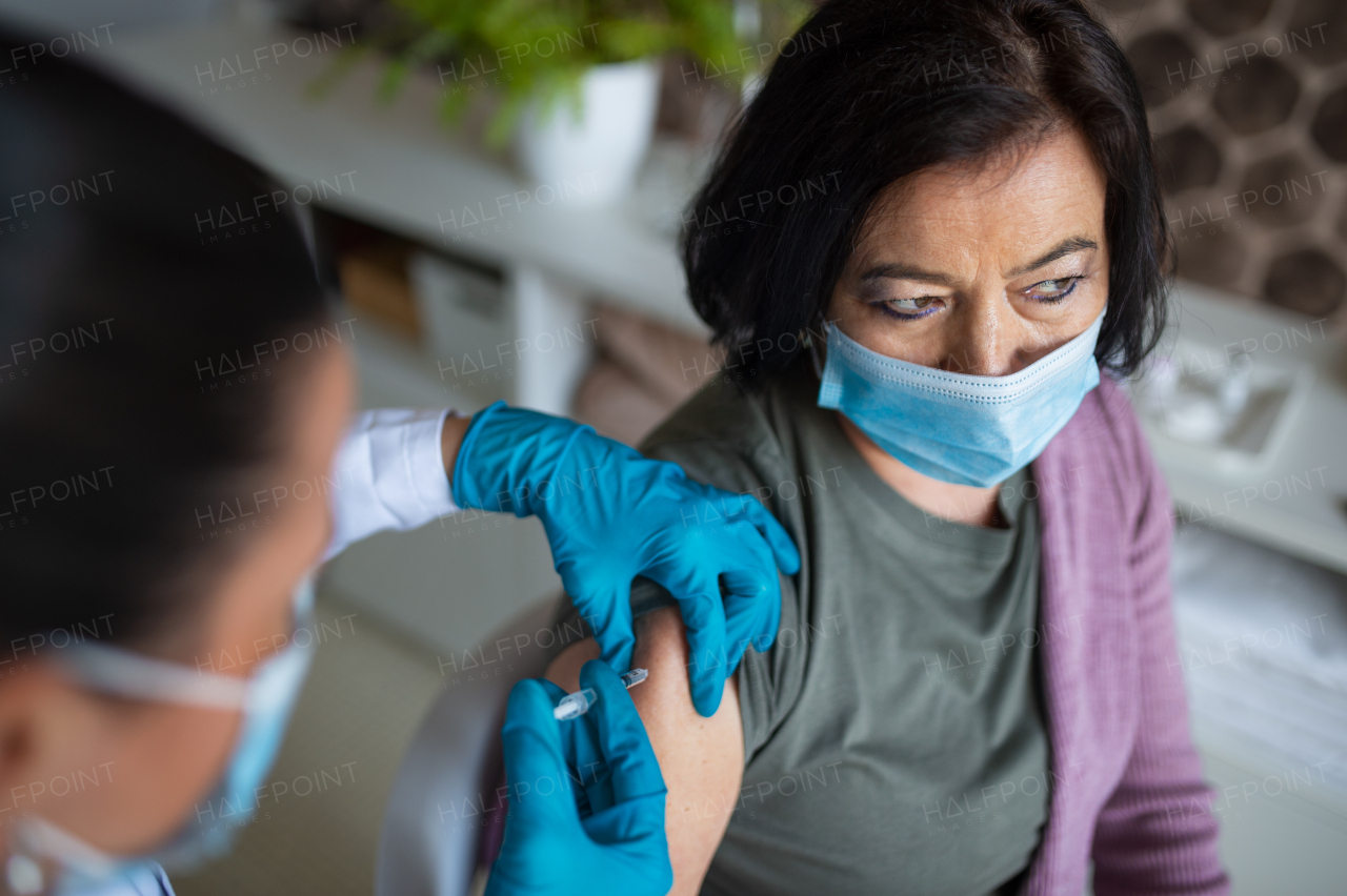 A top view of senior woman getting vaccinated in hospital, coronavirus and vaccination concept.