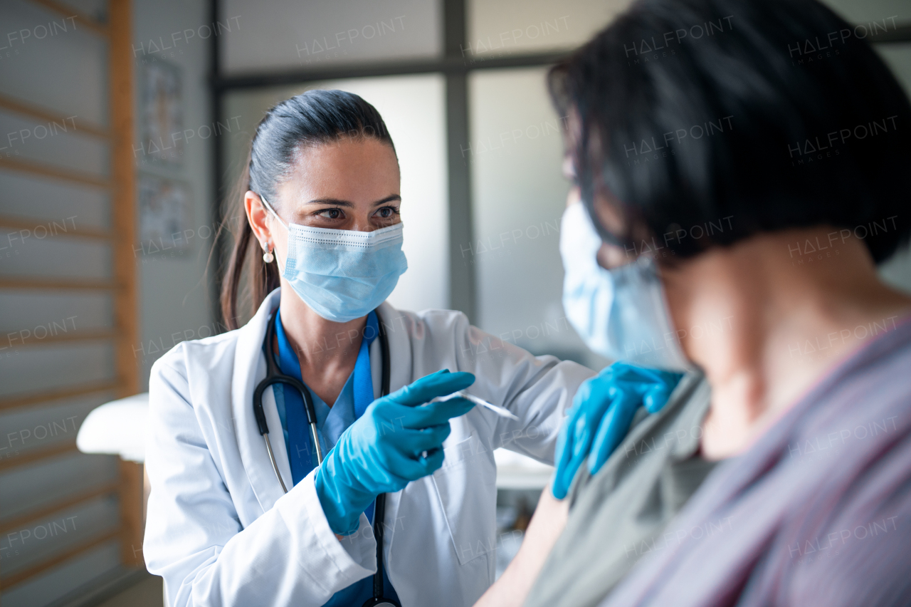 Mid woman with face mask getting vaccinated in hospital, coronavirus and vaccination concept.