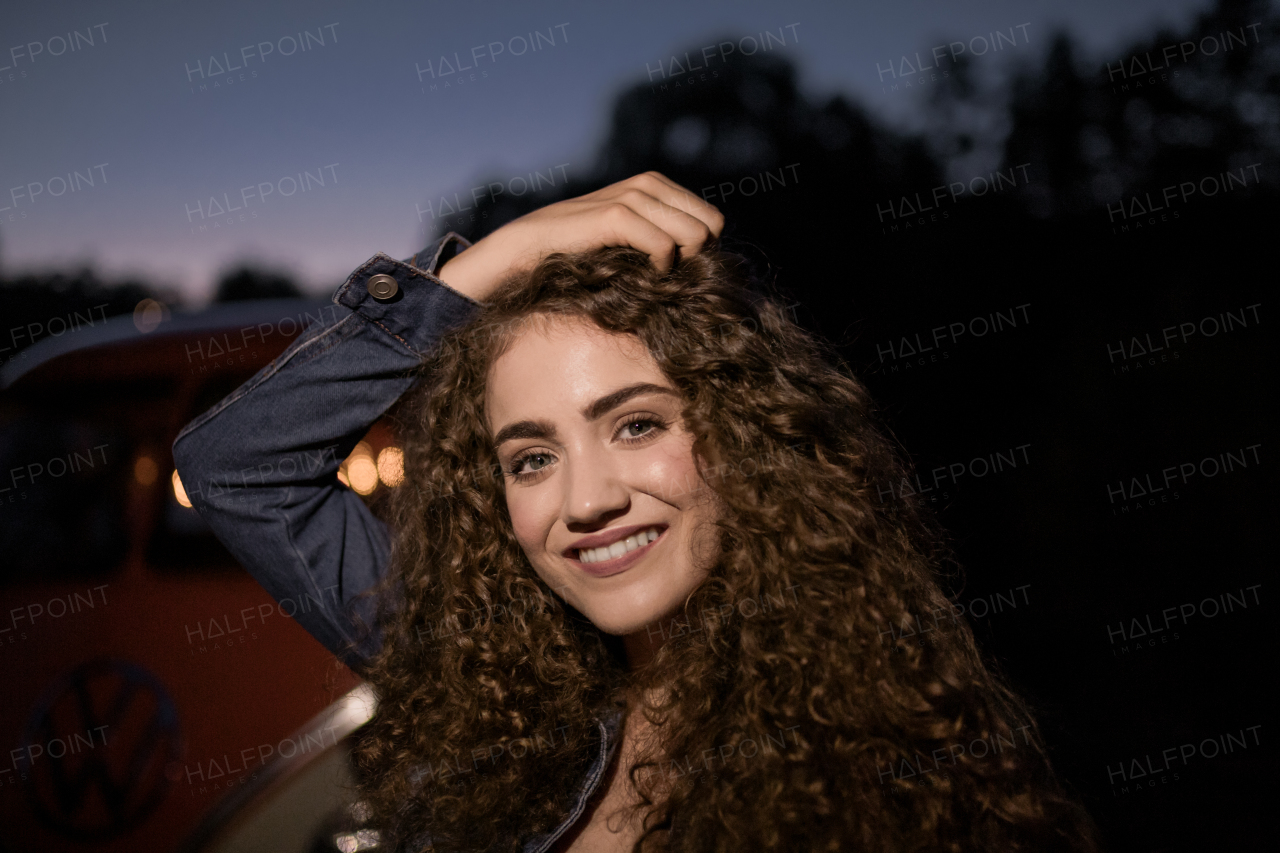 A portrait of a young girl standing outdoors at night in the countryside.