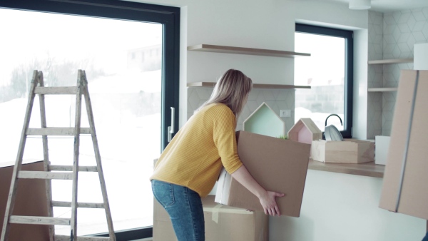 A young happy couple furnishing new house, talking. A moving in new home concept.