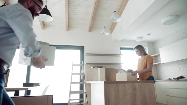 A joyful young happy couple furnishing new house, expressing excitement. A moving in new home concept. Slow motion.