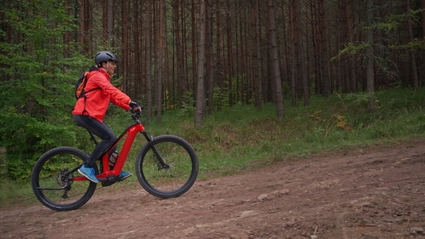 An active senior woman biker riding bike in nature on autumn day.