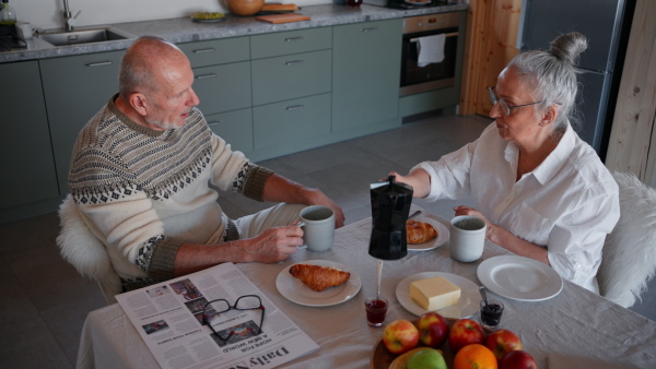 A senior couple having breakfast together at home.