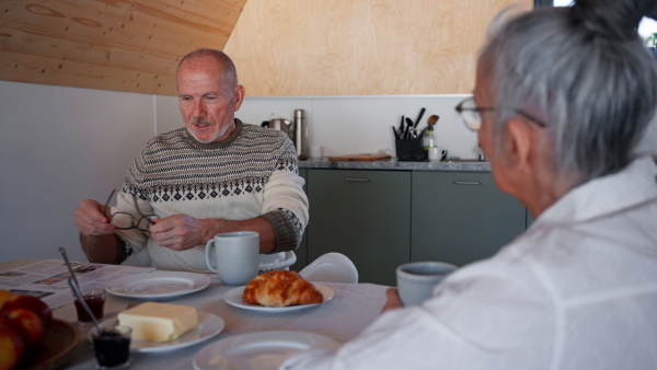 A senior couple having breakfast together at home.