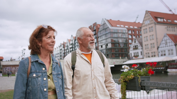 A happy senior couple tourists outdoors in historic town